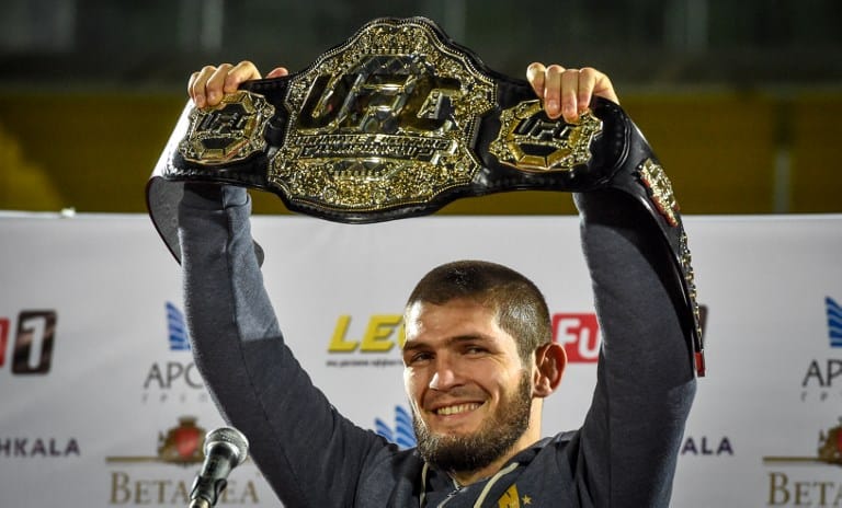 El campeón de Peso Ligero de la UFC Khabib Nurmagomedov alza su cinturón en su llegada a Makhachkala.