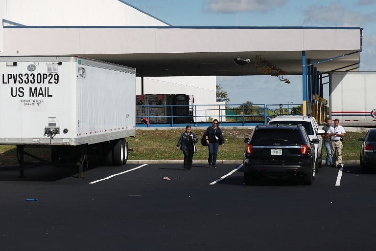 Trabajadores de correos son vistos en el complejo por donde pasó el paquete bomba de dirigido al Sendador Cory Booker en Opa Locka, Florida.